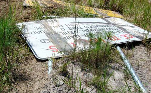It looks like vandals have done a burn out on this toppled sign. It looks like vandals have done a burn out on this toppled sign.